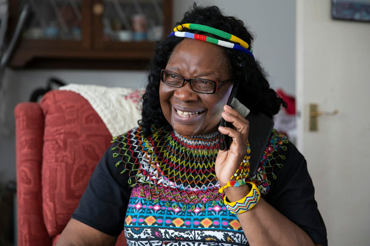 Older woman smiling while talking on the phone at home