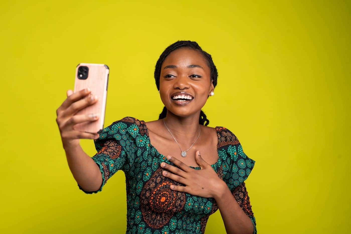 Young woman smiling and taking a selfie with her phone