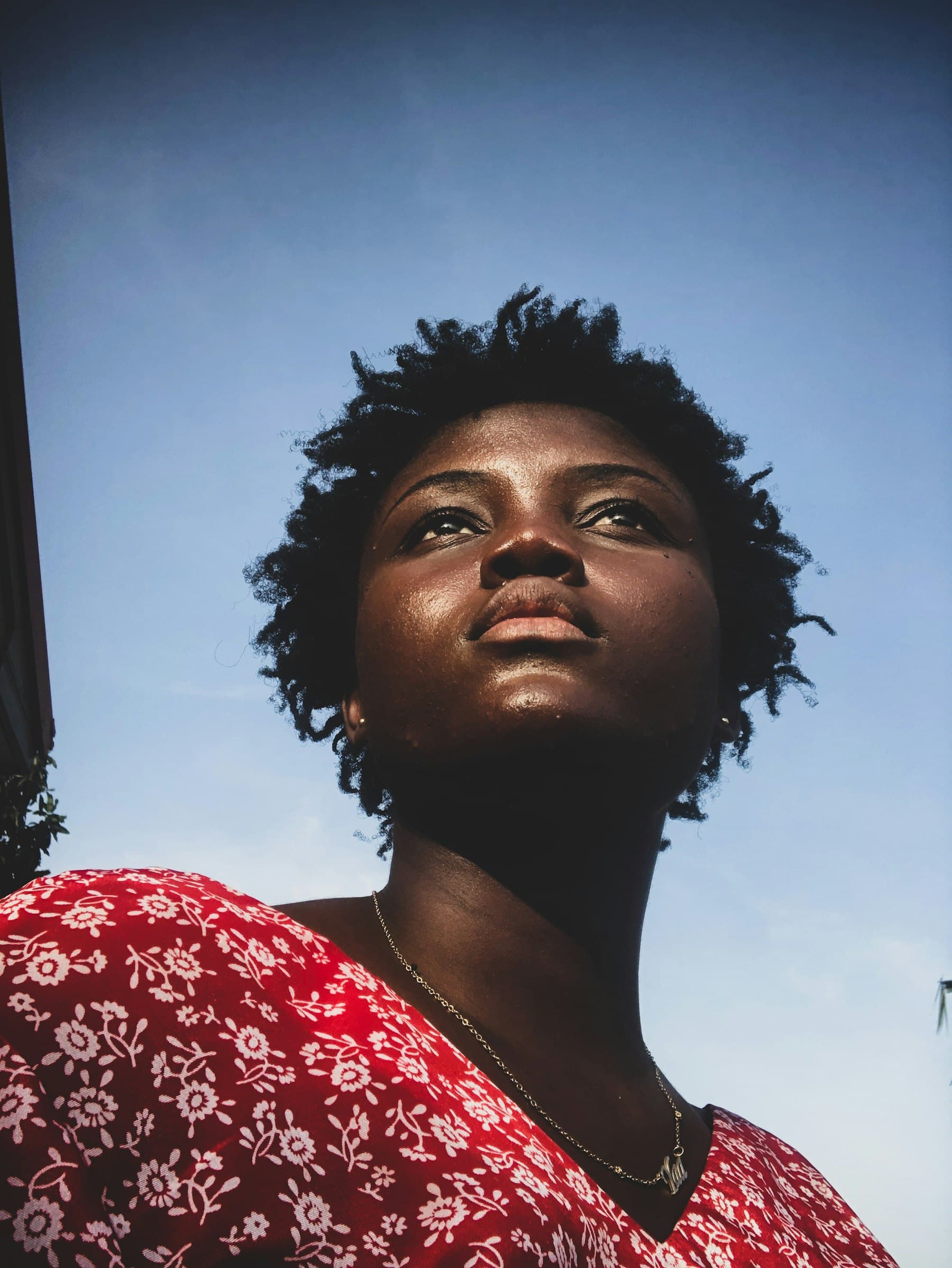 Woman looking up toward the sky with a hopeful expression
